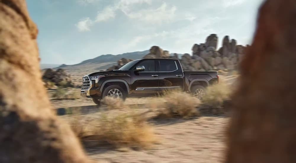 A grey 2023 Toyota Tundra is shown from the side while off-road.