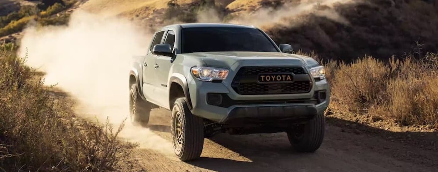A grey 2022 Toyota Tacoma Trail is shown fromt he front at an angle after leaving a used Toyota dealer.