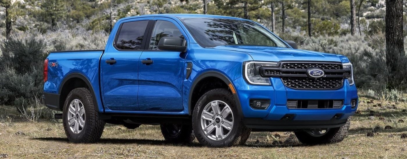 A blue 2024 Ford Ranger STX is shown parked in a clearing.