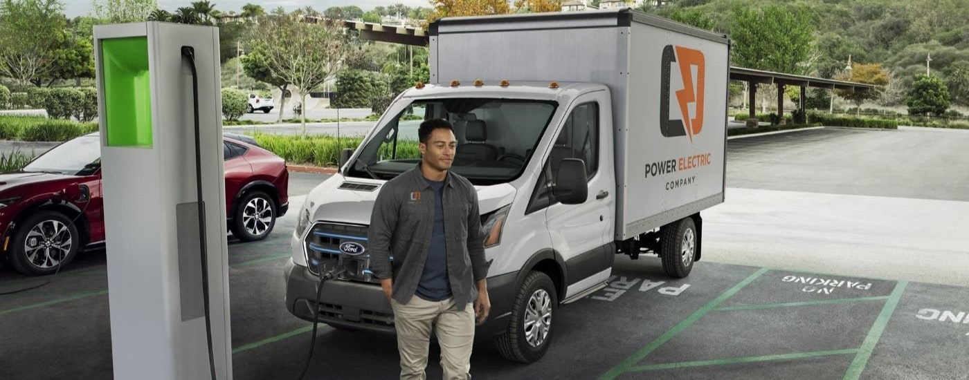 A white 2023 Ford E-Transit is shown charging after looking at electric vehicles for sale.