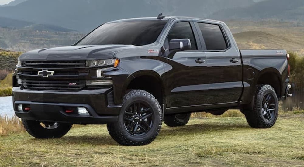 A black 2021 Chevy Silverado 1500 Z71 Trail Boss is shown from the front at an angle after leaving a dealer that has used trucks for sale.