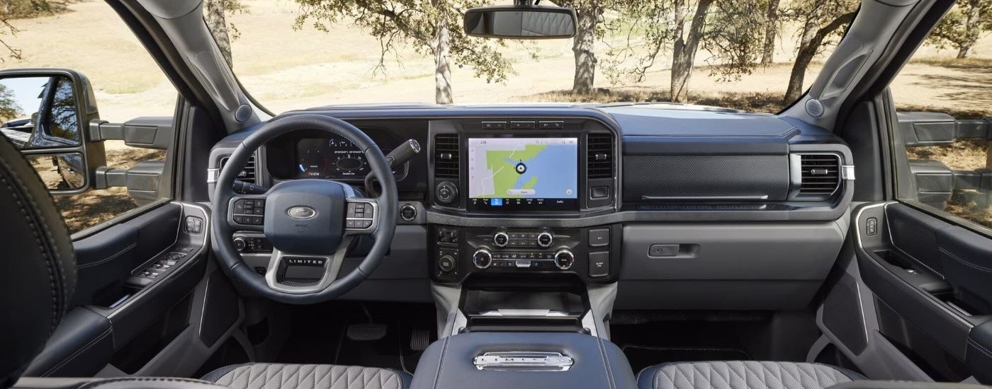 The infotainment screen and black dash are shown in a 2024 Ford Super Duty F-350 Limited.