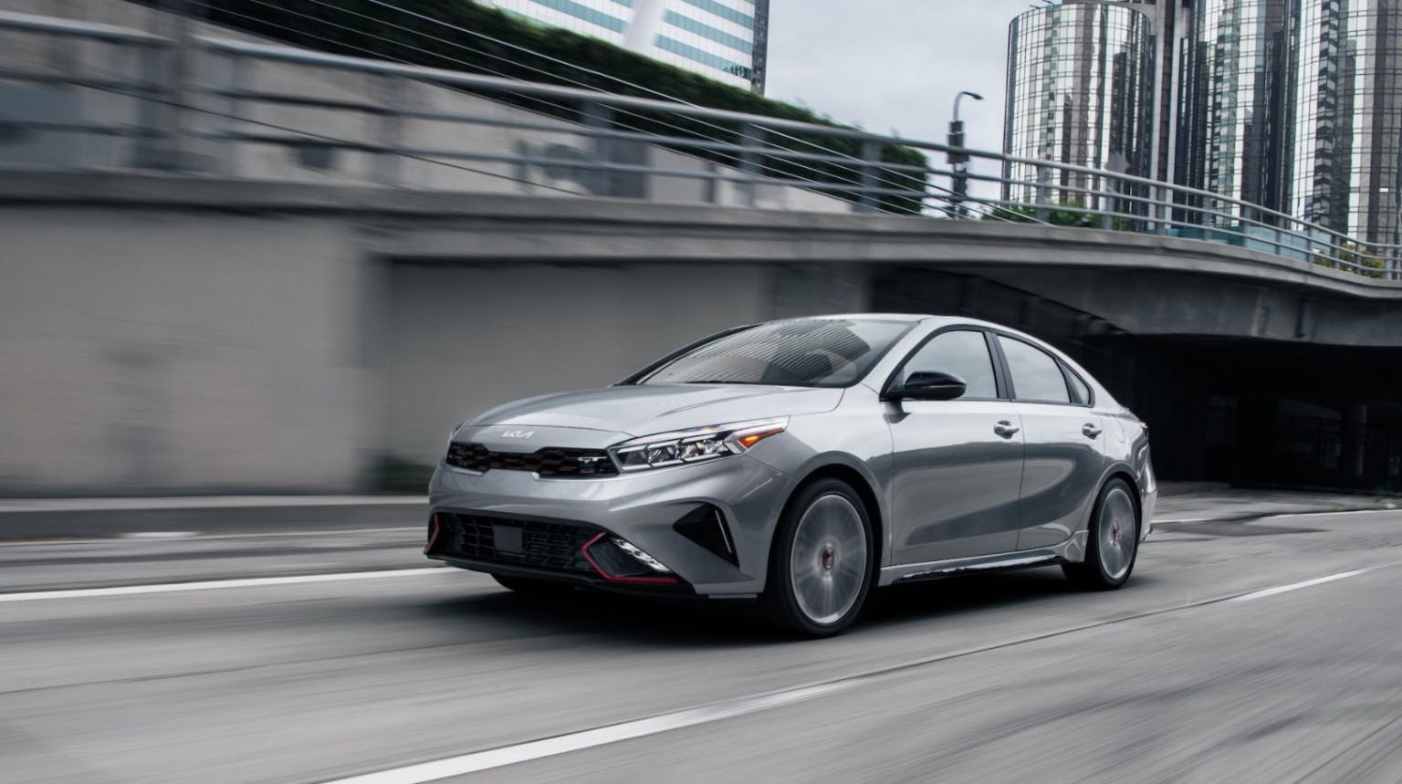 2024 Kia Forte GT driving on a highway through a city