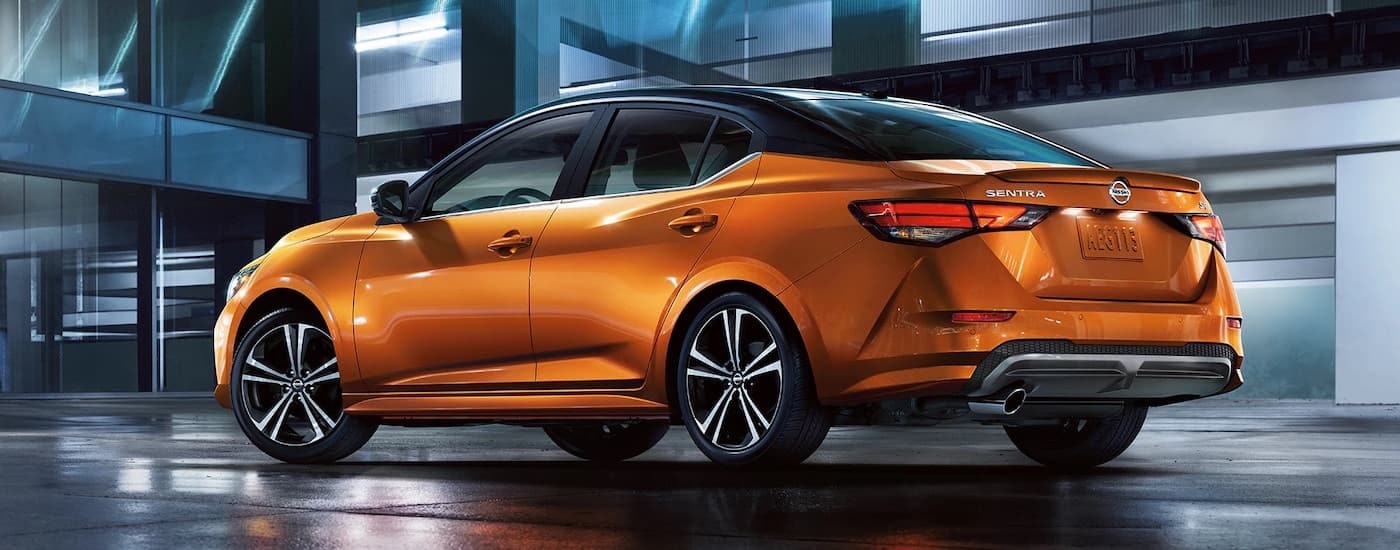 An orange 2023 Nissan Sentra is shown from the rear at an angle.