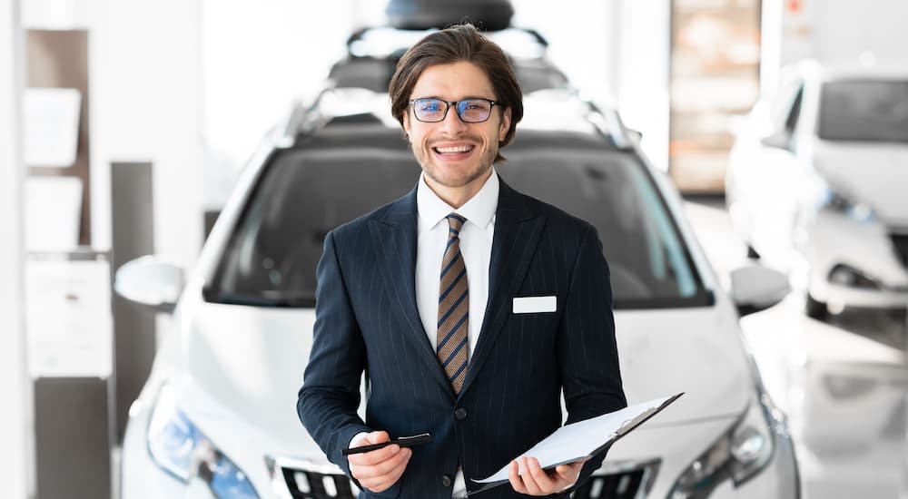 A salesman is shown holding financing paperwork.