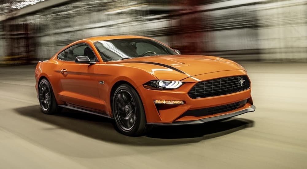 An orange 2021 Ford Mustang Ecoboost HPP is shown from the front at an angle after leaving a dealer that offers bad credit car loans near Lebanon, NH.