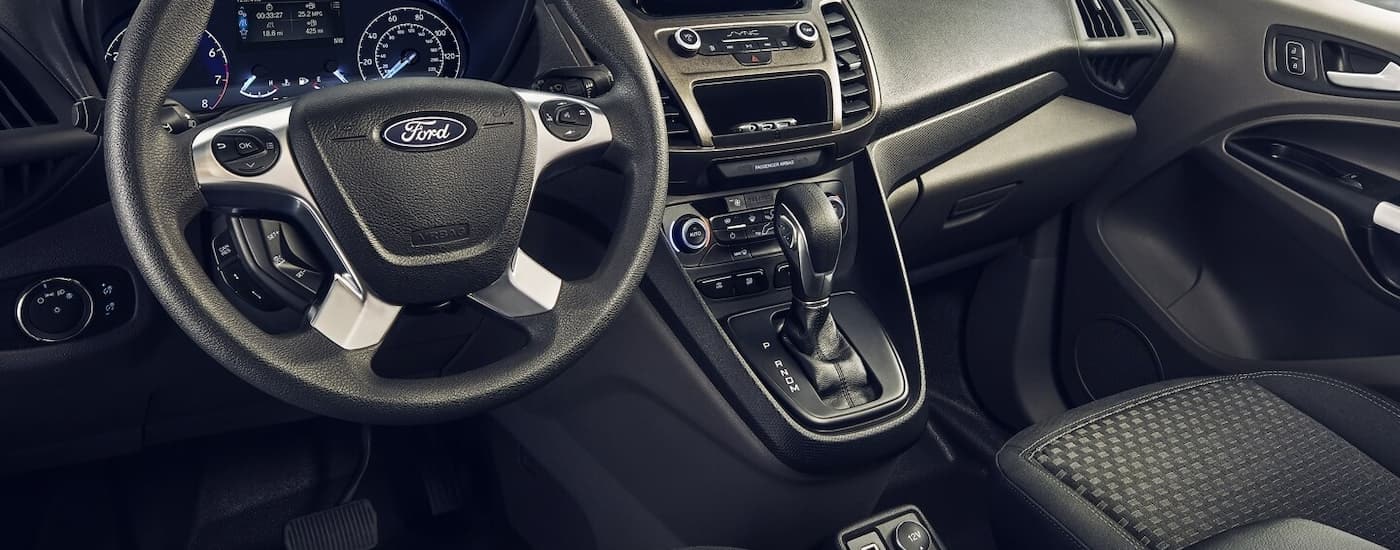 A close up of the steering wheel and center console of a 2023 Ford Transit Connect is shown.
