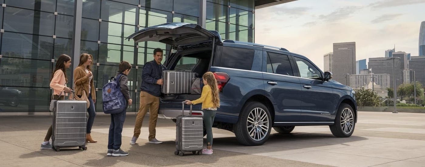 A blue 2024 Ford Expedition is shown being loaded with suitcases at an airport.