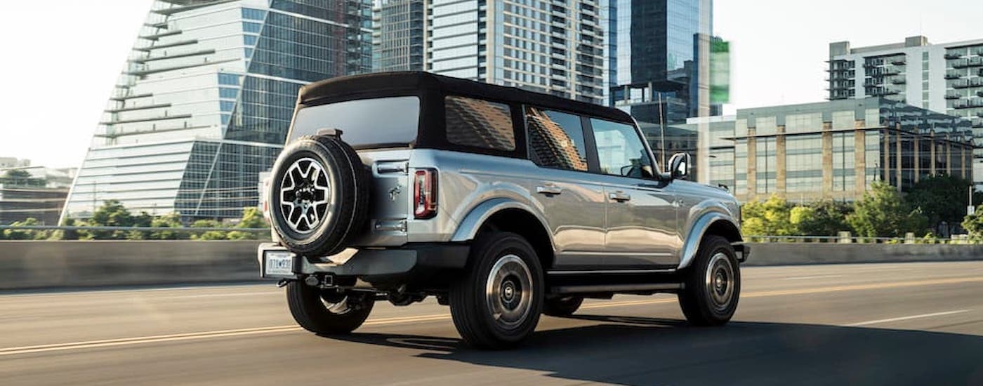A silver 2021 Ford Bronco Outer Banks is shown from the rear at an angle.