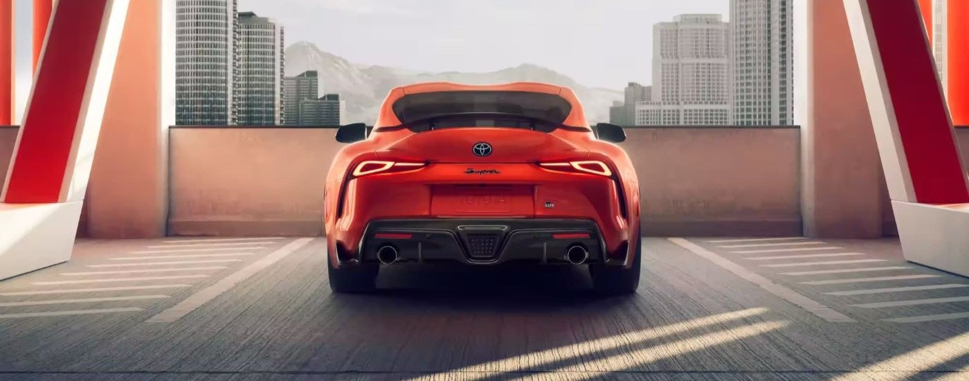An orange 2024 Toyota GR Supra 45th Anniversary Edition is shown from behind in a parking garage.