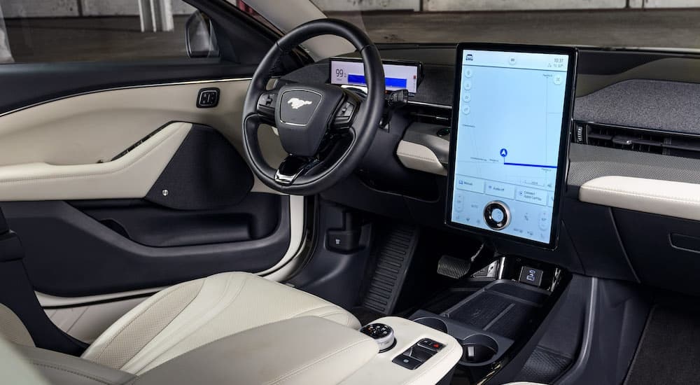 The white interior of a 2024 Ford Mustang Mach-E is shown from the passenger seat.