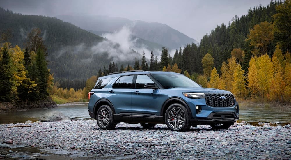 A blue 2025 Ford Explorer ST is shown from the side while off-road.
