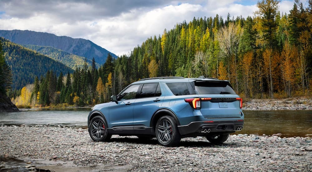 A blue 2025 Ford Explorer ST is shown from the rear at an angle while off-road.