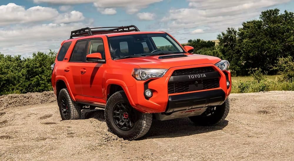 An orange 2023 Toyota 4Runner TRD Pro is shown from the front at an angle while off-road after leaving a Toyota dealership.