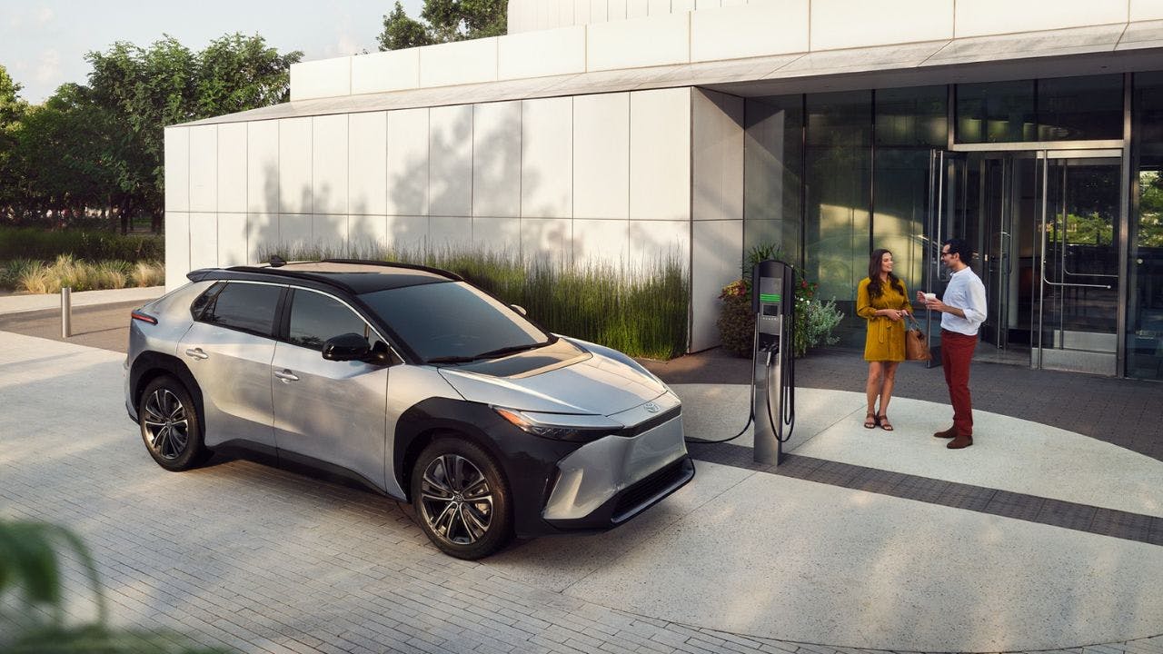 Couple chatting in front of a Toyota bz4x