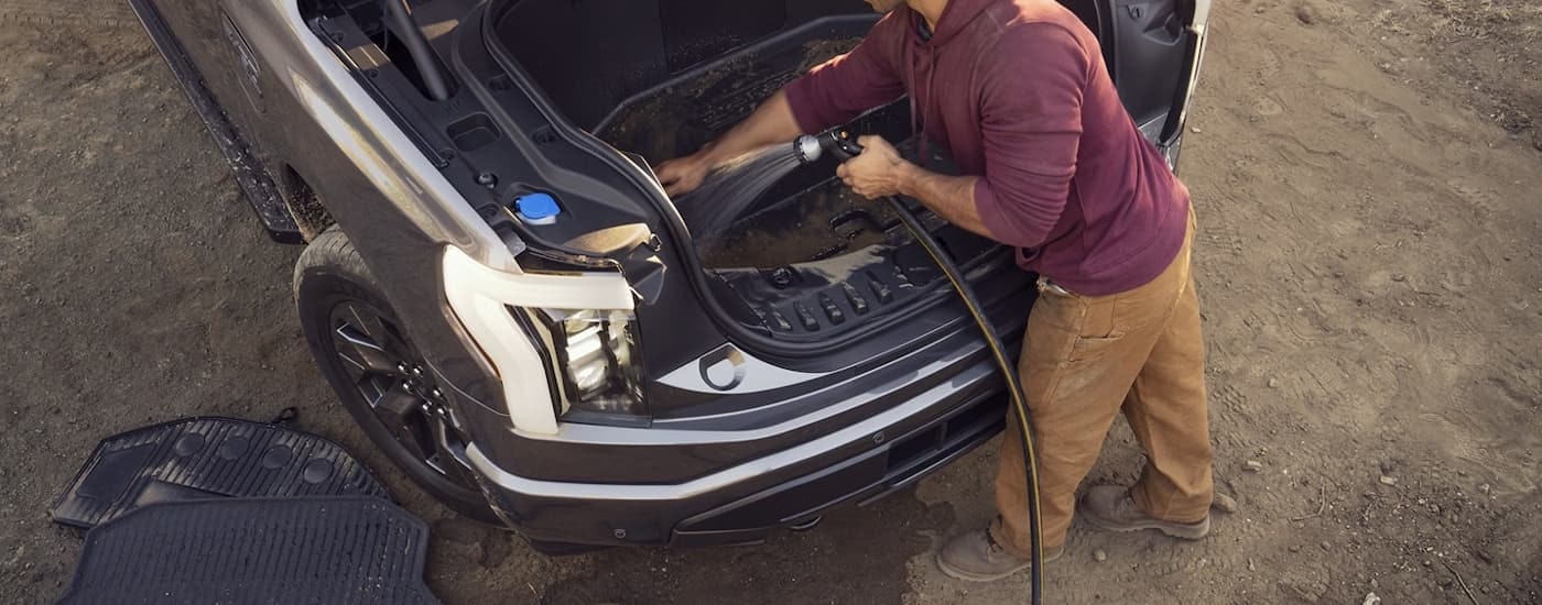 A person is cleaning out the frunk in a 2024 Ford F-150 Lightning.