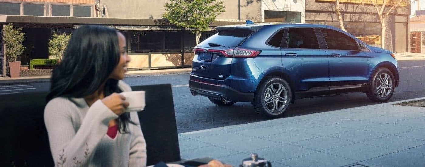 A blue 2018 Ford Edge is shown on a city street after looking for used SUVs for sale in Westminster.