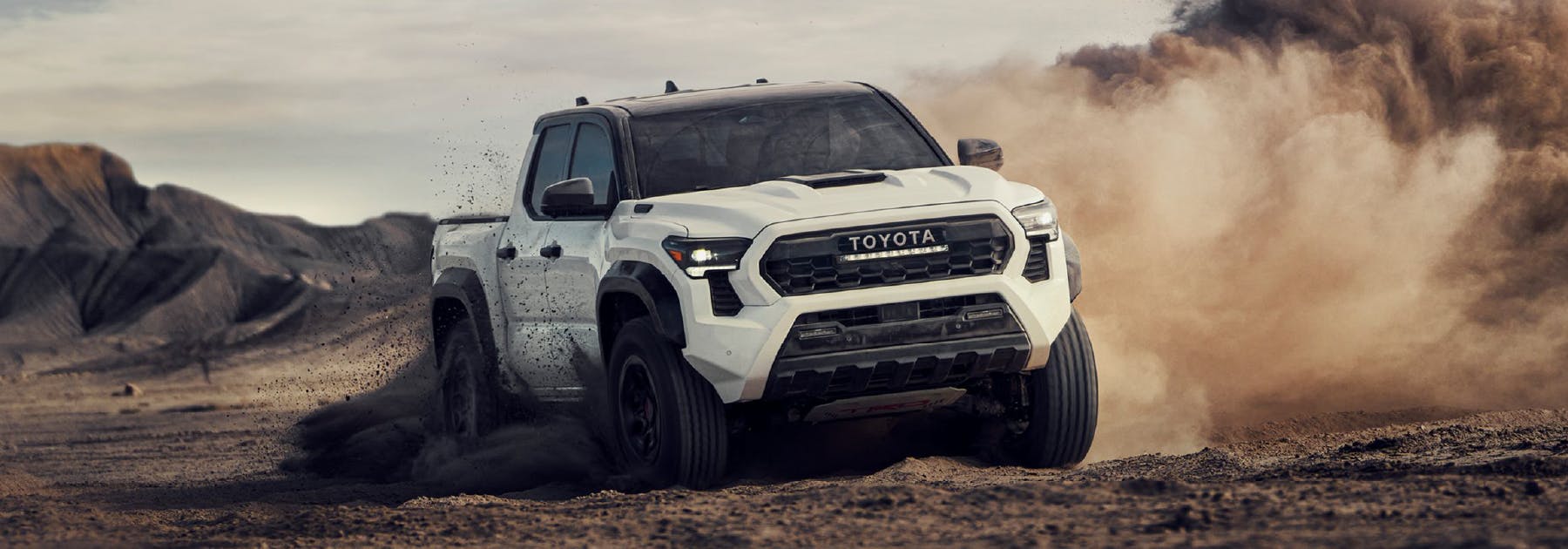 white Toyota Tacoma off-road driving