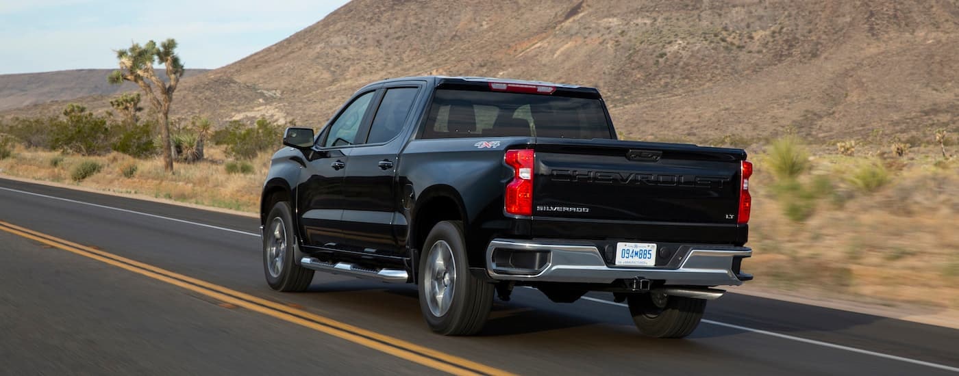 A black 2022 Chevy Silverado LT is shown from the rear at an angle after leaving a dealer that has used trucks for sale in Westminster.