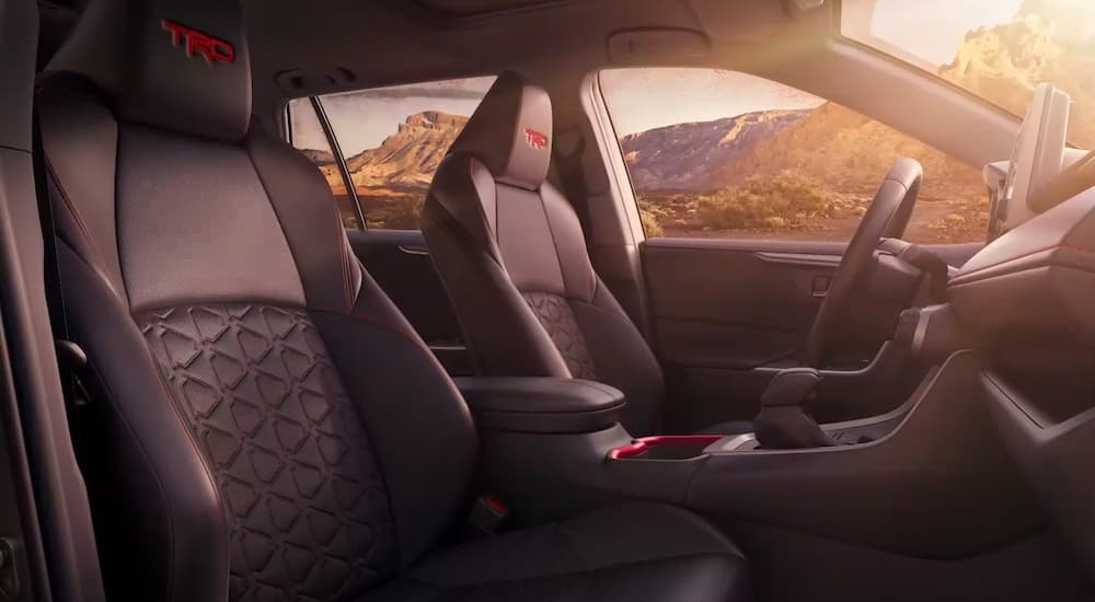 The black interior of a 2024 Toyota RAV4 TRD is shown from the passenger side.