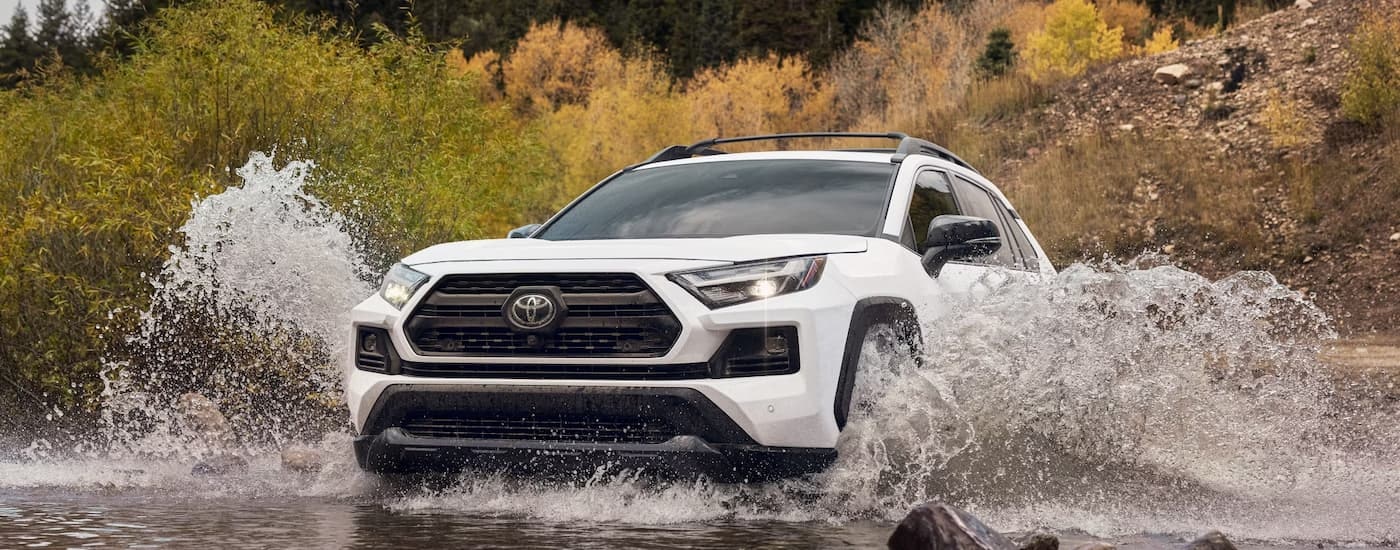 A white 2024 Toyota RAV4 TRD Off-Road is driving through a river.
