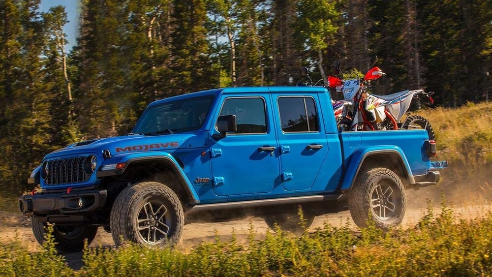 Jeep Gladiator 4xe in the woods with a dirt bike