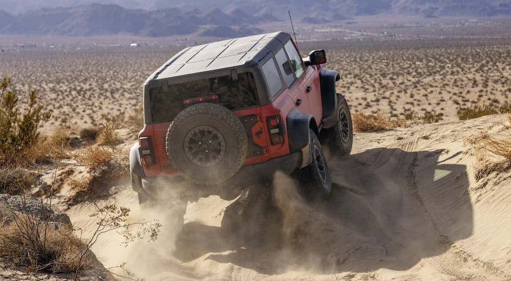 A red 2024 Ford Bronco Raptor is shown from the rear at an angle after leaving a Ford dealer near Walpole.