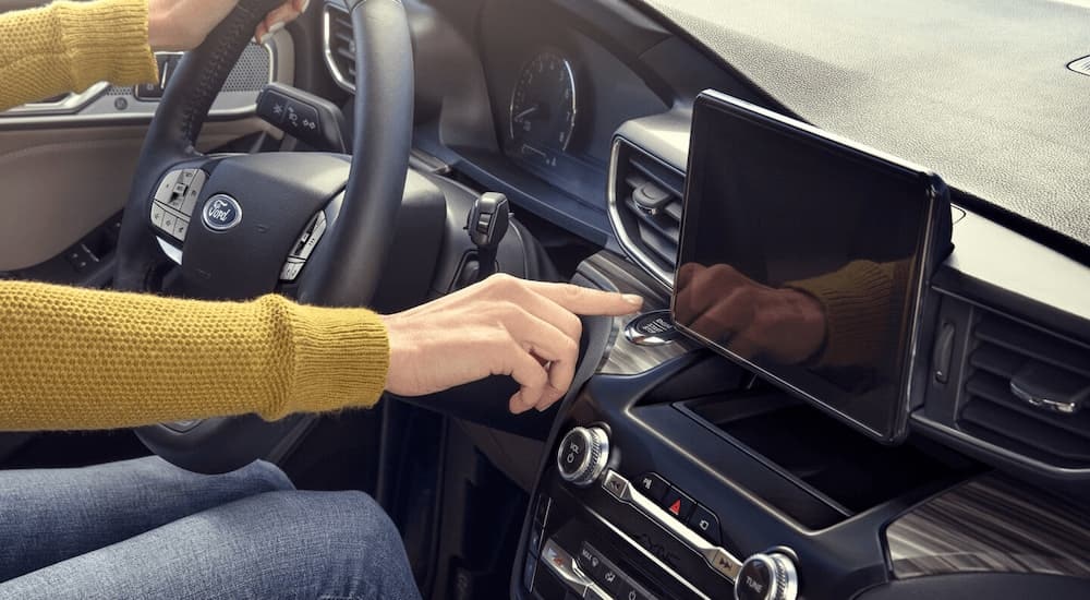 A close up of a hand using the infotainment screen in a 2024 Ford Explorer.