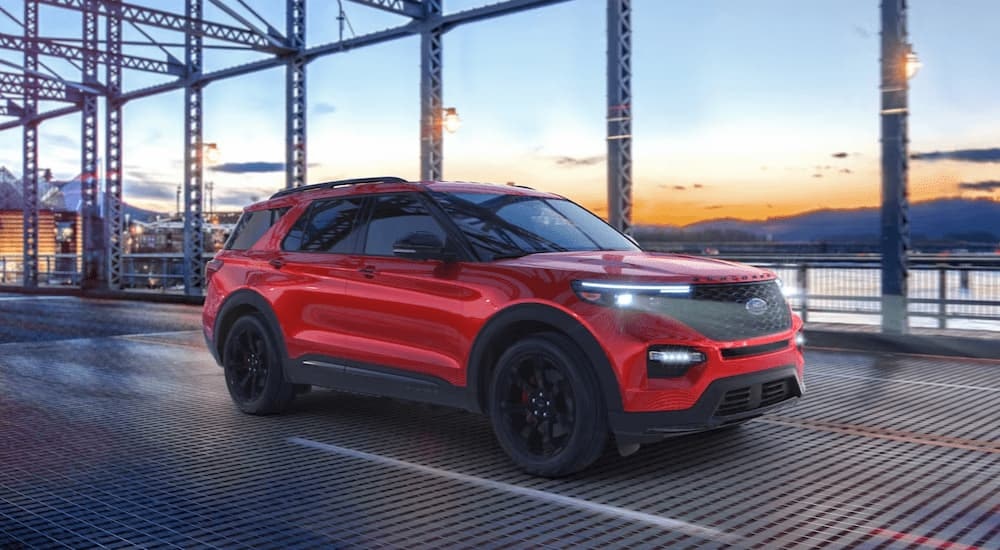 A red 2024 Ford Explorer ST is driving on a bridge.