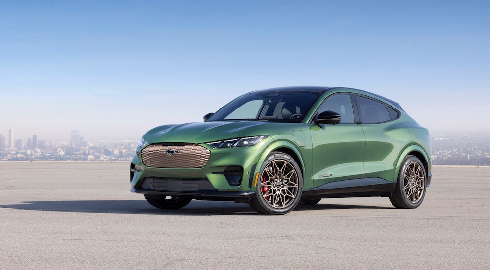 A green 2024 Ford Mustang Mach-E GT is shown from the front at an angle.