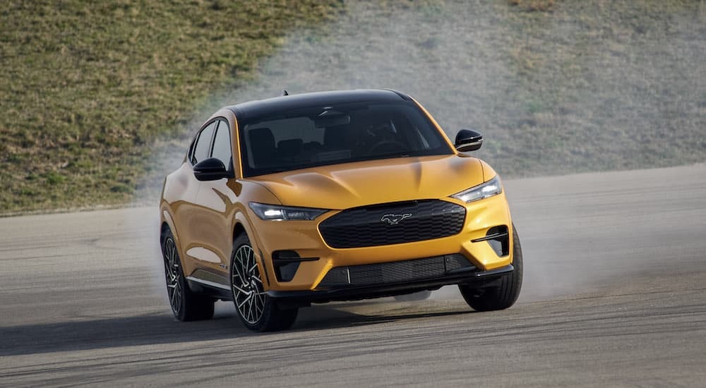 A yellow 2024 Ford Mustang Mach-E GT is shown from the front while drifting after leaving a Ford dealer near Claremont.