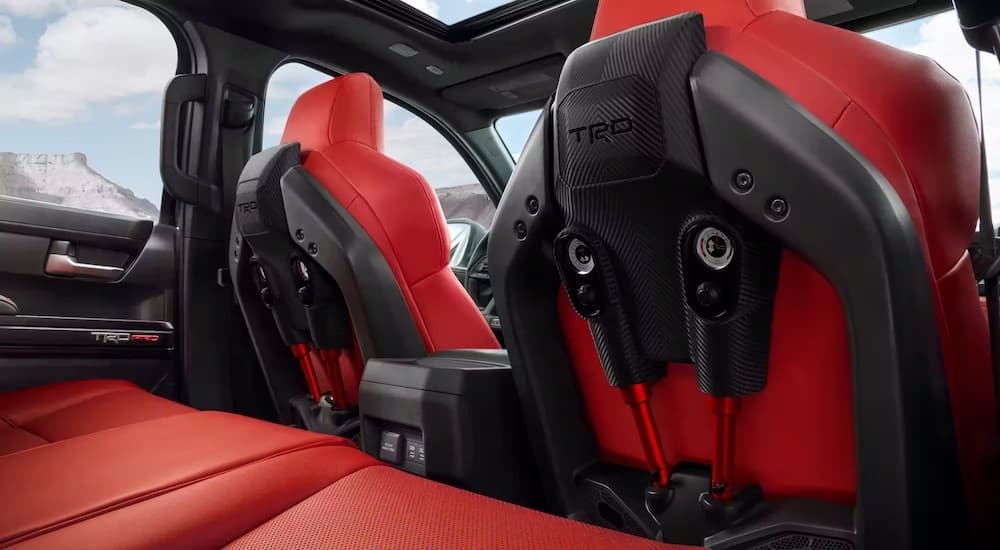 The red IsoDynamic seats in a 2024 Toyota Tacoma TRD Pro are shown from the rear seat.