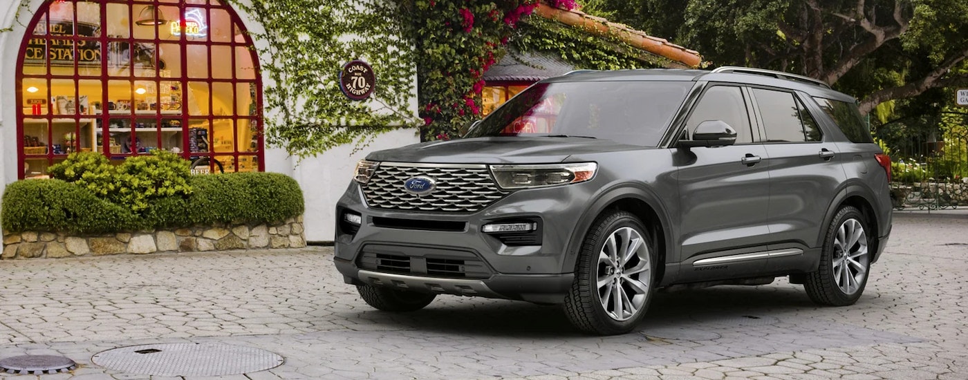 A grey 2024 Ford Explorer Platinum parked in a garden courtyard.