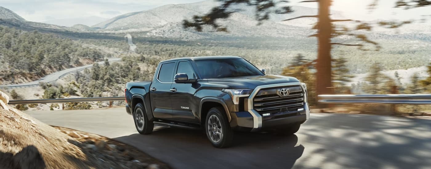 A grey 2024 Toyota Tundra Limited Crewmax driving up a hill.