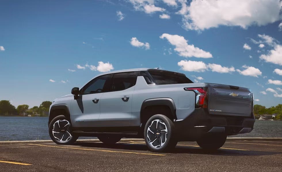 2025 Chevrolet Silverado EV parked in front of a lake