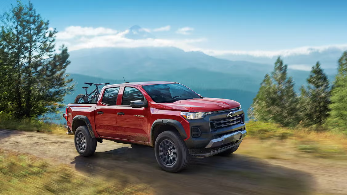 2025 Chevy Colorado driving on a dirt road with bikes in the bed