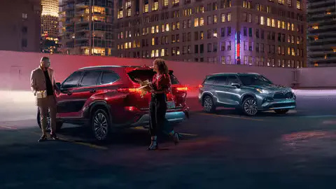 Couple entering a new red Toyota 