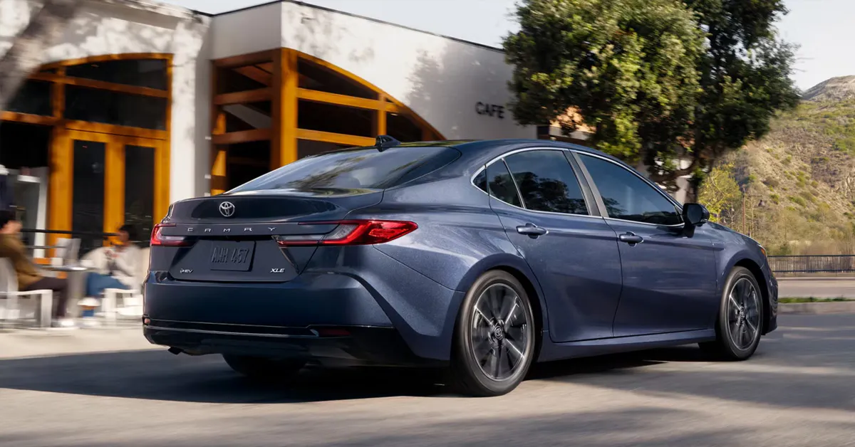 2026 Toyota Camry sedan driving on a city street, featuring sleek body lines