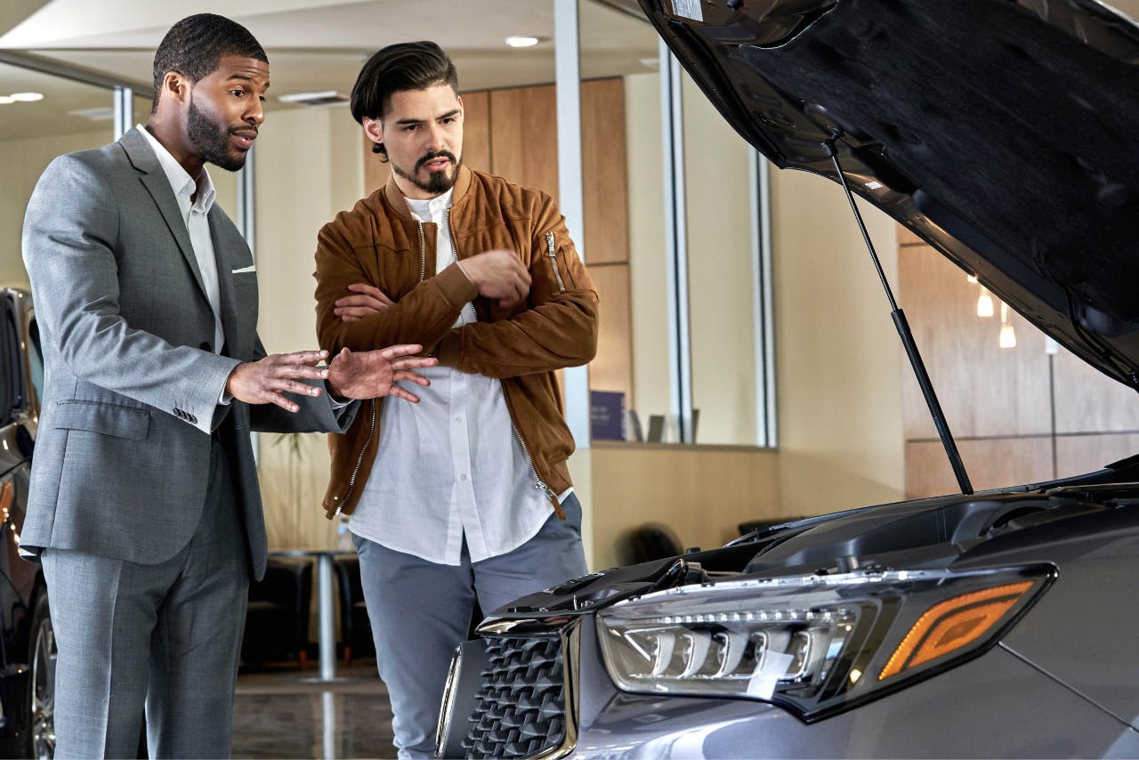 Sales representative showing new vehicle to customer