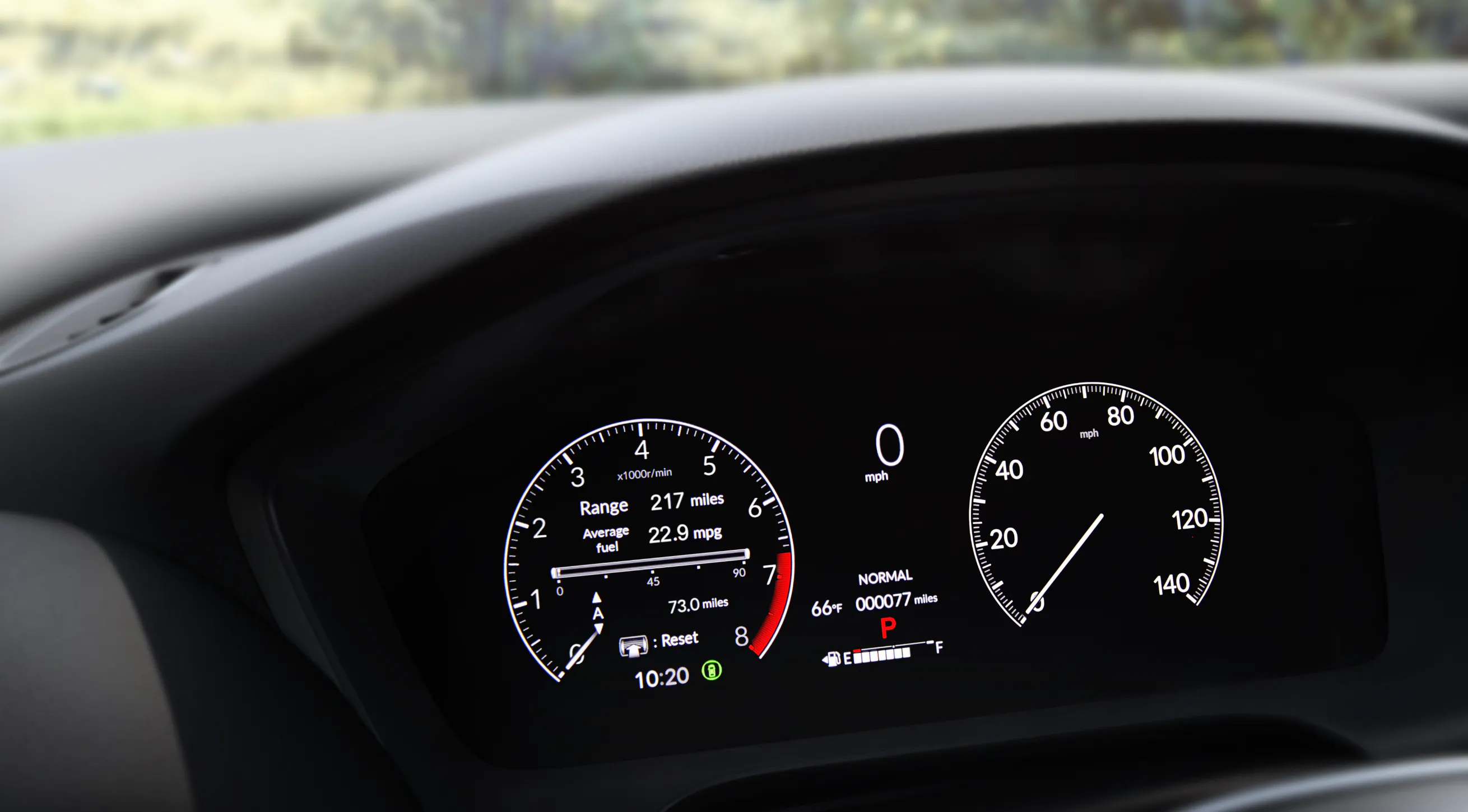 Close-up of a Honda digital instrument cluster displaying vehicle speed, fuel level, driving mode, and trip information.