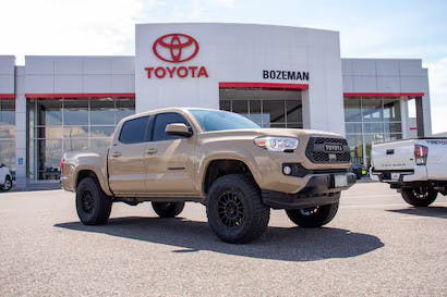 Beige Toyota Tacoma truck parked in front of Toyota of Bozeman Montana