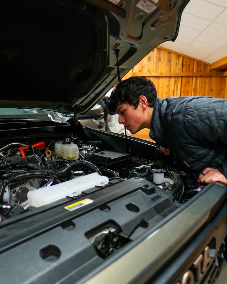 boy looking under toyota hood