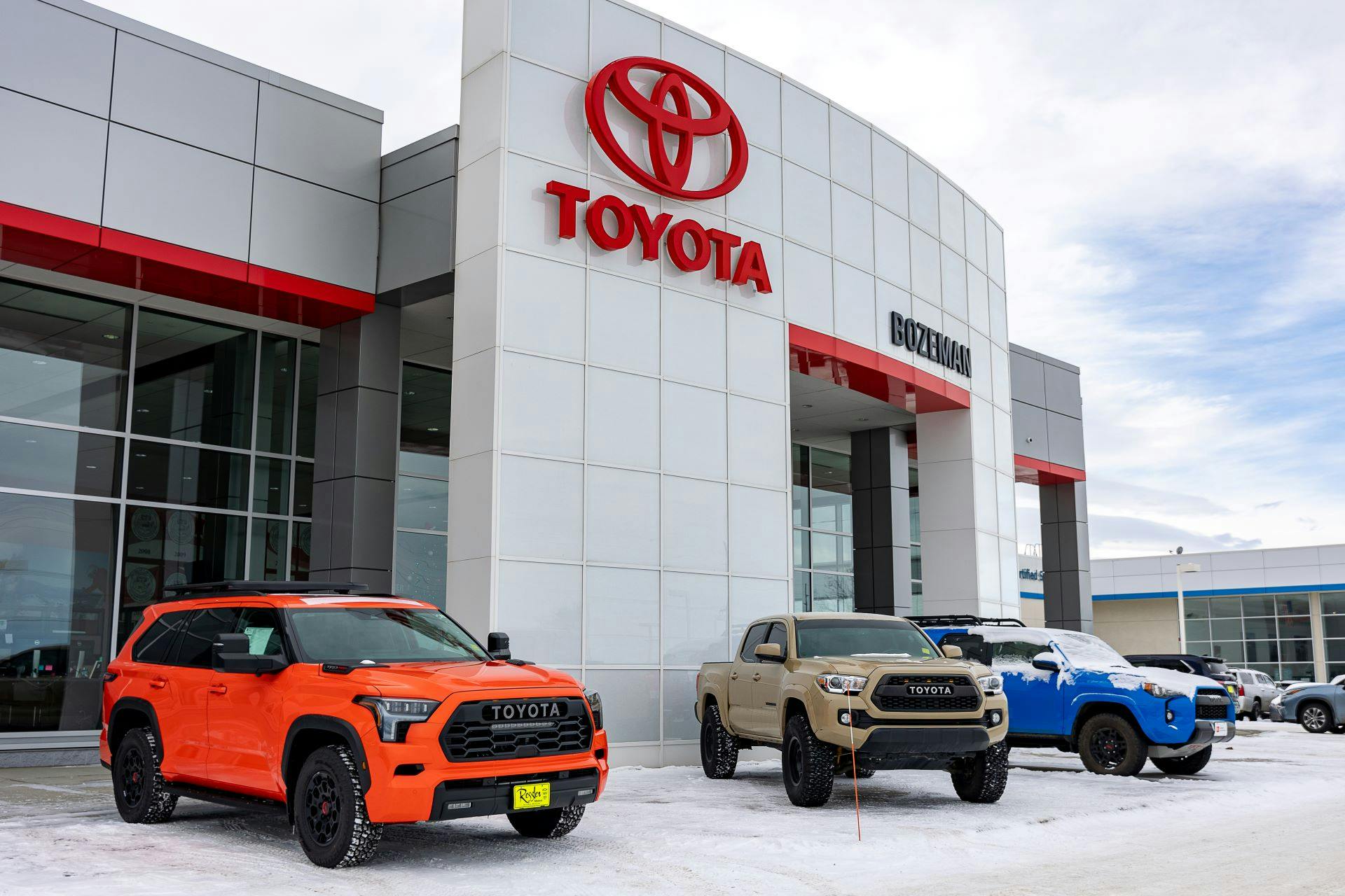 burnt orange 2024 TRD pro Sequoia, brown Tacoma, and blue TRD 4Runner parked at Toyota of Bozeman near Billings Montana