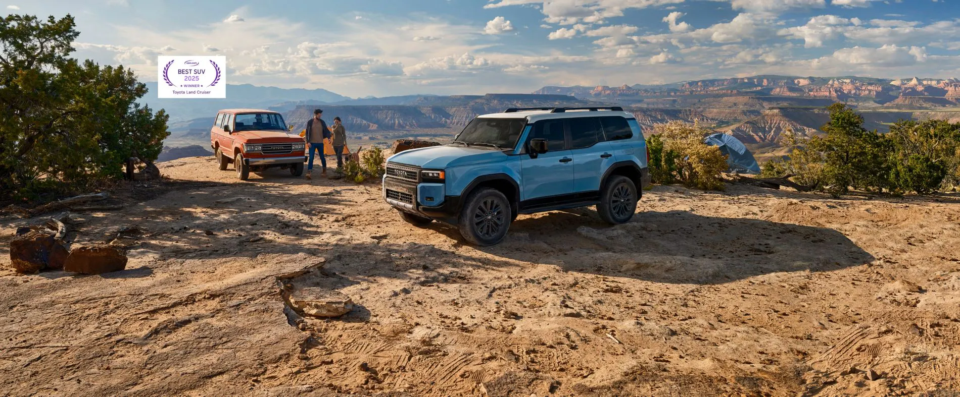 Two Toyota Land Crusier SUVs parked on top of rocky peak
