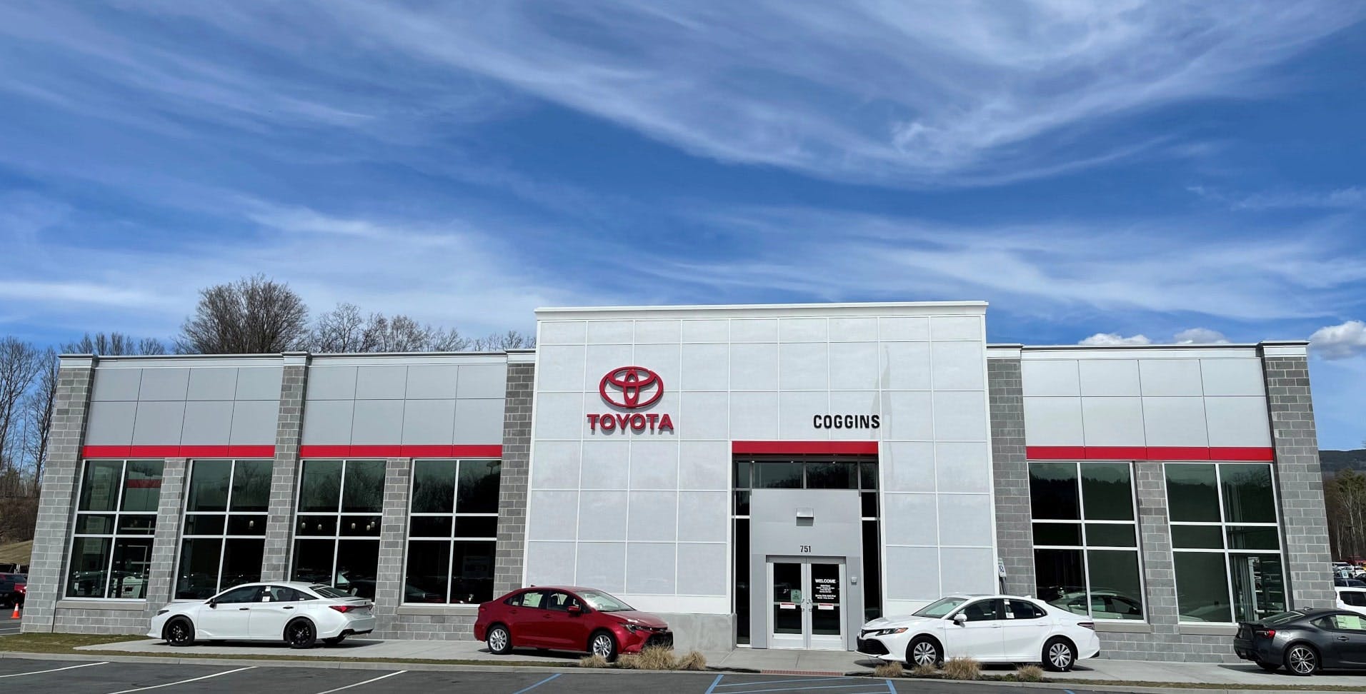 the front of Coggins Toyota under a beautiful blue sky