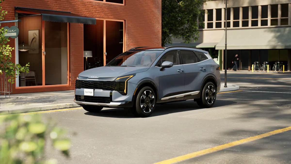 A blue-gray 2026 Kia Sportage on a downtown street.