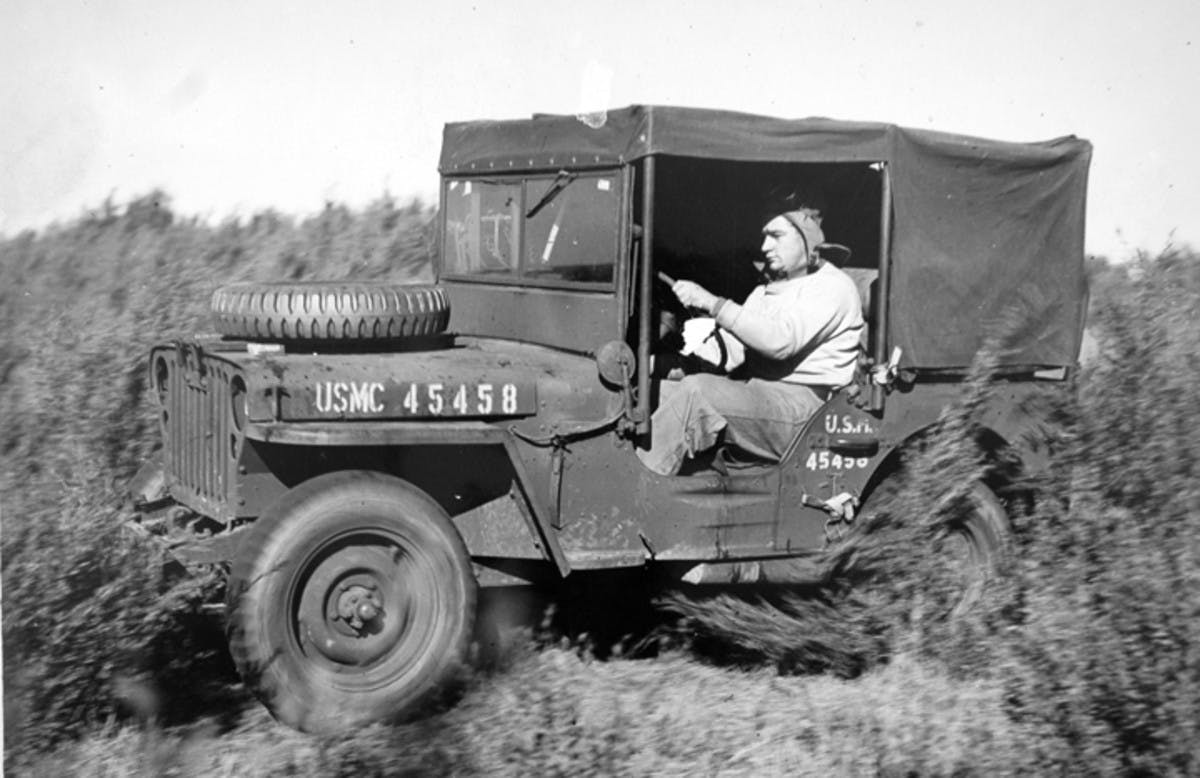 black and white image of man driving car