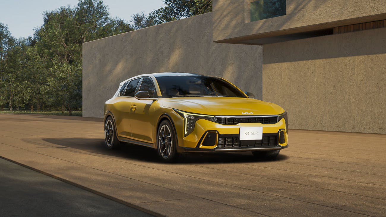 yellow kia k4 hatchback outside of a house