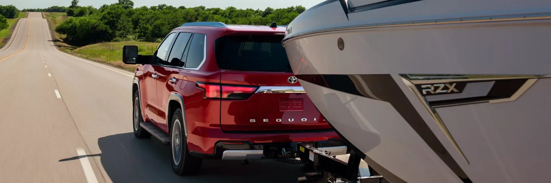 A Supersonic Red 2025 Sequoia Capstone towing a boat