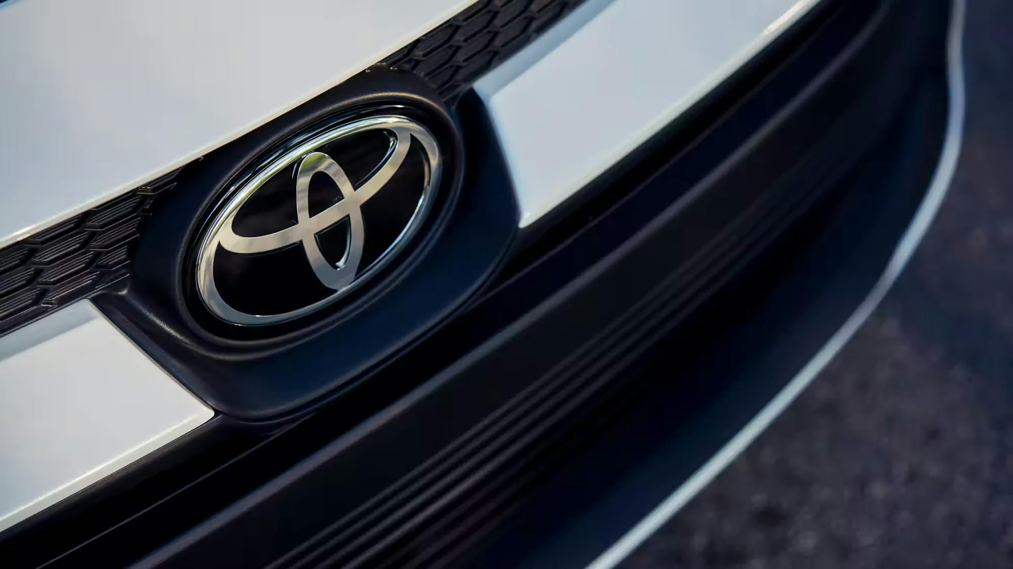 Toyota logo close up view on a white Toyota Corolla.